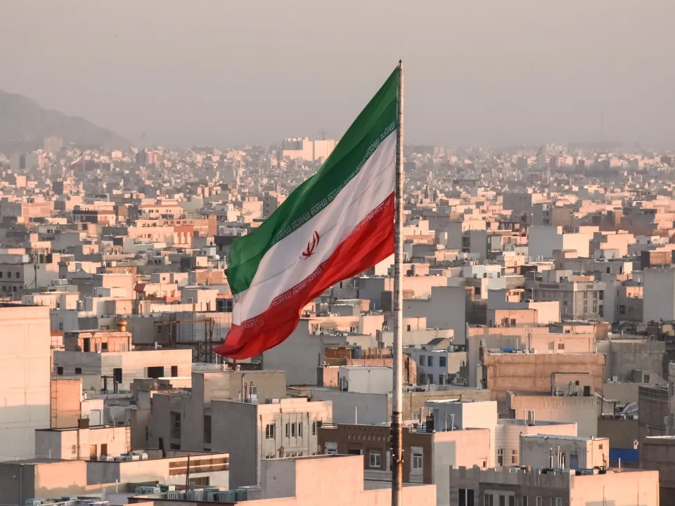 Iranian flag waving with cityscape on background in Tehran, Iran